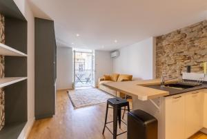 a kitchen and living room with a stone wall at Duplex Curistes - Conciergerieland in Dax