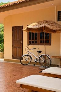 a bike parked in front of a house with an umbrella at Lilo House, Thaimueang Beach in Thai Muang +13 photos