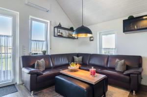 a living room with a leather couch and a table at Ferienwohnung Romanas in Ostrach
