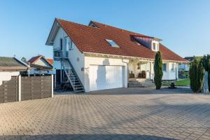 a house with a garage in a driveway at Ferienwohnung Romanas in Ostrach