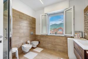 a bathroom with a toilet and a sink and a window at Casa Lago Vicky in Omegna