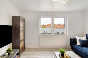 a living room with a blue couch and a window at Ferienwohnung City in Emden