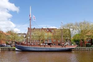 a boat sitting in the water in front of a building at Ferienwohnung City in Emden
