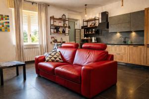 ein rotes Sofa in einem Wohnzimmer mit Küche in der Unterkunft Bombrelais in Apice