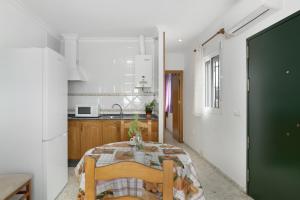 a kitchen with a table and a green door at Casa Paqui Bustos 1 in Conil de la Frontera