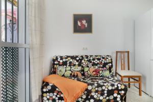 a living room with a couch with an orange blanket at Casa Paqui Bustos 1 in Conil de la Frontera