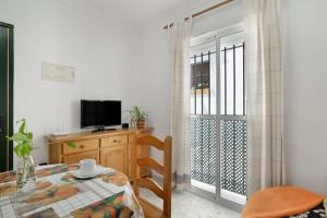 a room with a table and a sliding glass door at Casa Paqui Bustos 1 in Conil de la Frontera