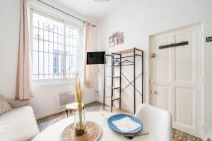 a living room with a table and a window at Logement cosy centre Beaucaire - C2 in Beaucaire +11 photos