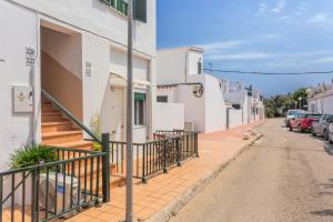 a street with white buildings and cars parked on the street at Cala'n Blanes Park 228 in Cala en Blanes