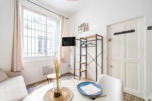 a living room with a table and chairs and a window at Logement cosy centre Beaucaire - C2 in Beaucaire