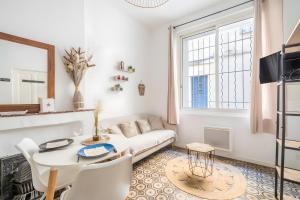 a living room with a white couch and a table at Logement cosy centre Beaucaire - C2 in Beaucaire
