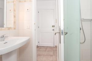 a white bathroom with a sink and a shower at Cala'n Blanes Park 228 in Cala en Blanes +12 photos