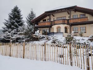 a house with a fence in the snow at Felsenland Idyll in Erfweiler