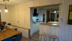 a kitchen and dining room with a table and a counter at Gite Les Pivoines in Saint-Robert +11 photos