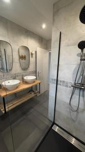 a bathroom with two sinks and two mirrors at Gite Les Pivoines in Saint-Robert