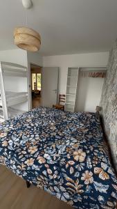 a bedroom with a bed with a floral bedspread at Gite Les Pivoines in Saint-Robert