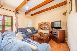 a living room with a blue couch and a tv at Mirabo ramonet in Caʼs Concos