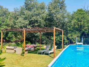 a pool with a gazebo and chairs next to a swimming pool at El Celler - Can Bonet in Sant Martí Vell