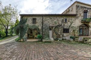 an old stone house with a brick driveway at El Celler - Can Bonet in Sant Martí Vell