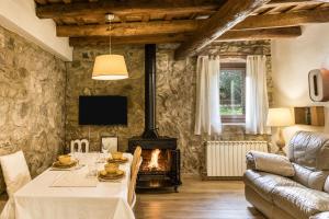 a living room with a table and a fireplace at El Celler - Can Bonet in Sant Martí Vell