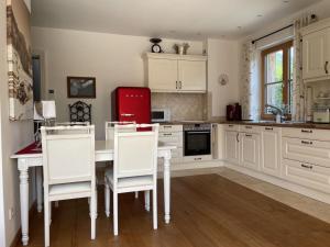 a kitchen with white cabinets and a table and chairs at Ferienwohnung Max 3 in Garmisch-Partenkirchen +30 photos