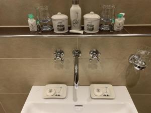 a white sink in a bathroom with bottles on a shelf at Ferienwohnung Max 3 in Garmisch-Partenkirchen