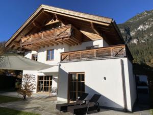 a white house with a wooden roof at Ferienwohnung Max 3 in Garmisch-Partenkirchen