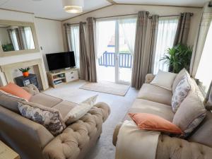 a living room with two couches and a television at Number 6 - Sandy Beach Holiday Park in Norwich