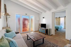 a living room with a couch and a table at Casa Papaya in Vila Nova De Cacela