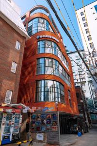 a tall red building in front of a building at D-Haus Hostel Dongdaemun in Seoul