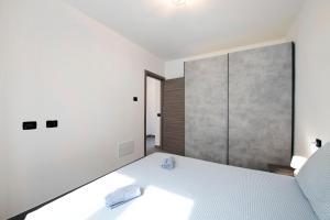 a bedroom with a white bed and a large window at Appartamento 8 Il Tornante in Nesso +16 photos