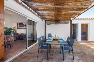 a dining room with a table and chairs at Casa Papaya in Vila Nova De Cacela +16 photos