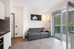 a living room with a couch and a balcony at Appartamento 8 Il Tornante in Nesso