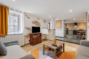 a living room with a couch and a table at Les Écrins de Campan in Campan