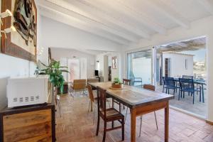 a living room with a table and chairs and a dining room at Casa Papaya in Vila Nova De Cacela