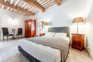 a bedroom with a bed and a table and chairs at La Grange Bessac in Violès