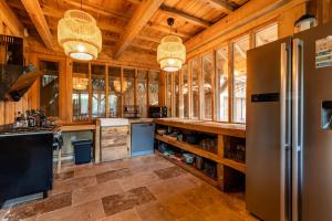 a large kitchen with wooden walls and wooden ceiling at Villa Chan-Ly in Lacanau +15 photos