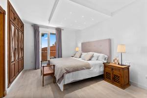 a bedroom with a bed and a table with a lamp at Front Line Beach Townhouse Estepona in Estepona +34 photos