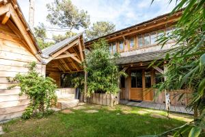 an exterior view of a wooden house with a yard at Villa Chan-Ly in Lacanau
