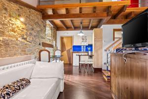 a living room with a white couch and a tv at C de Alborada del eo in Villameitide