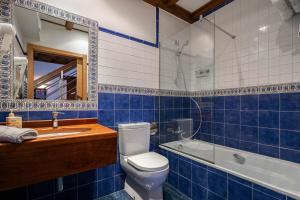 a blue tiled bathroom with a toilet and a sink at C de Alborada del eo in Villameitide +29 photos