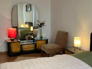 a bedroom with a bed and a mirror and a chair at Auf dem Karlsberg in Weilburg