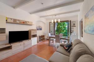 a living room with a couch and a tv and a table at Casa Sole e Mare in Arenzano