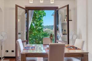 a dining room with a table and a large window at Casa Sole e Mare in Arenzano