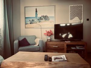 a living room with a tv and a table at Zone 3 in Erfurt