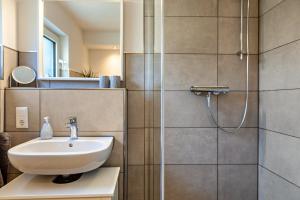 a bathroom with a sink and a shower at Ferienwohnung Gabler in Möhnesee +10 photos