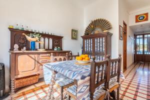 a dining room with a table with a bowl of oranges on it at Sa Torre in Port de Soller +19 photos