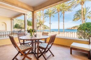 a dining room with a table and chairs and the ocean at Sa Torre in Port de Soller