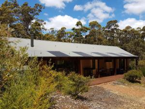 a house with solar panels on the side of it at Jarrah Grove Forest Retreat in Rosa Glen