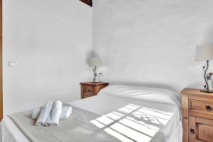 a white bed with two white towels on it at Casas al Alba 2 in Zahora